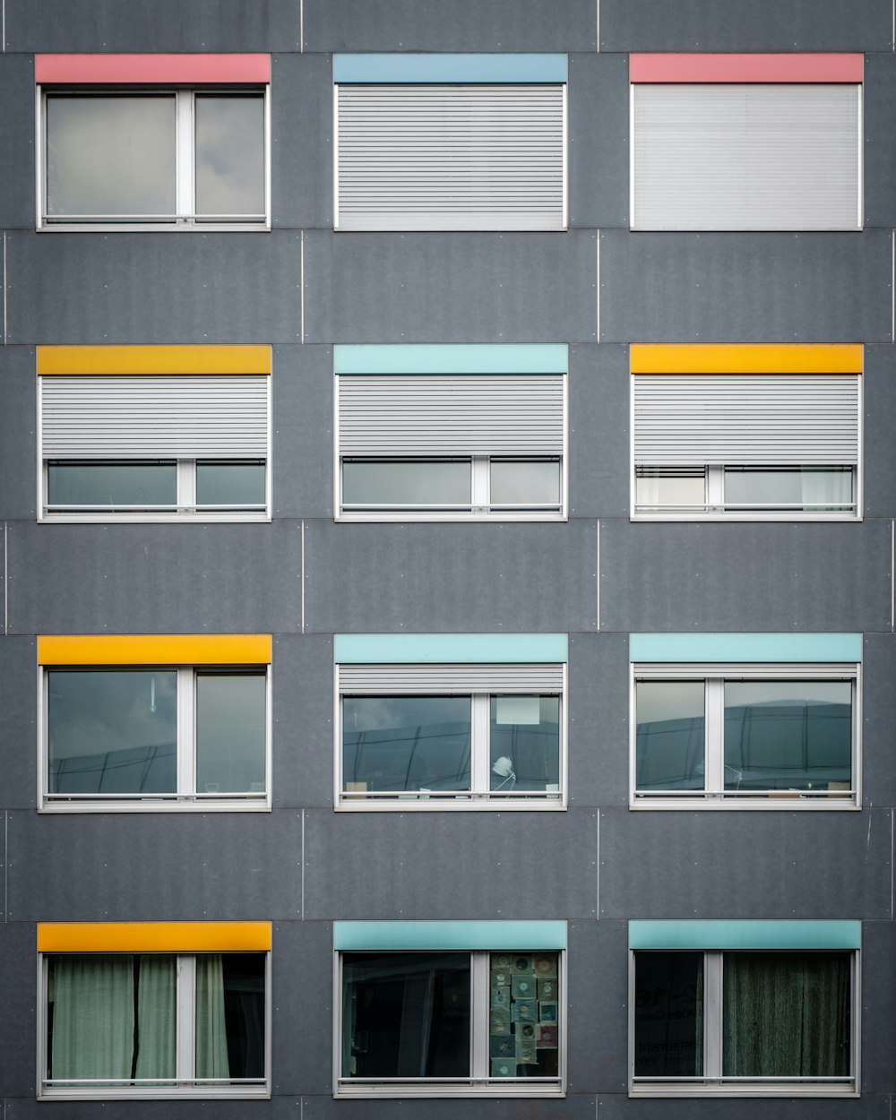 낮 동안 투명한 유리창이 있는 회색 콘크리트 건물의 사진