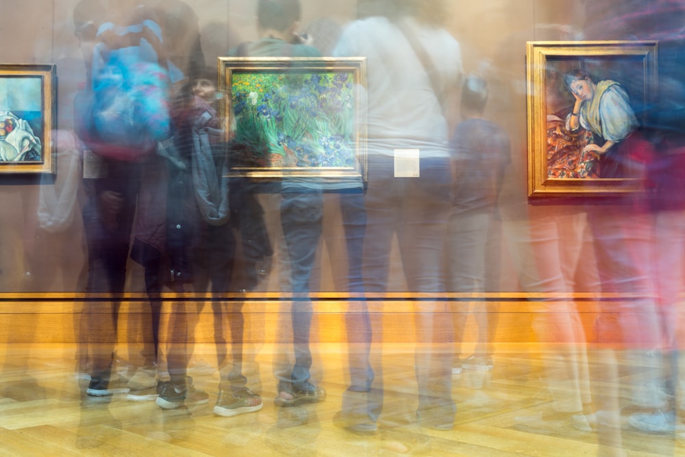 people gathering inside painting exhibit