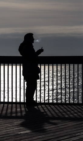 person using vape near body of water