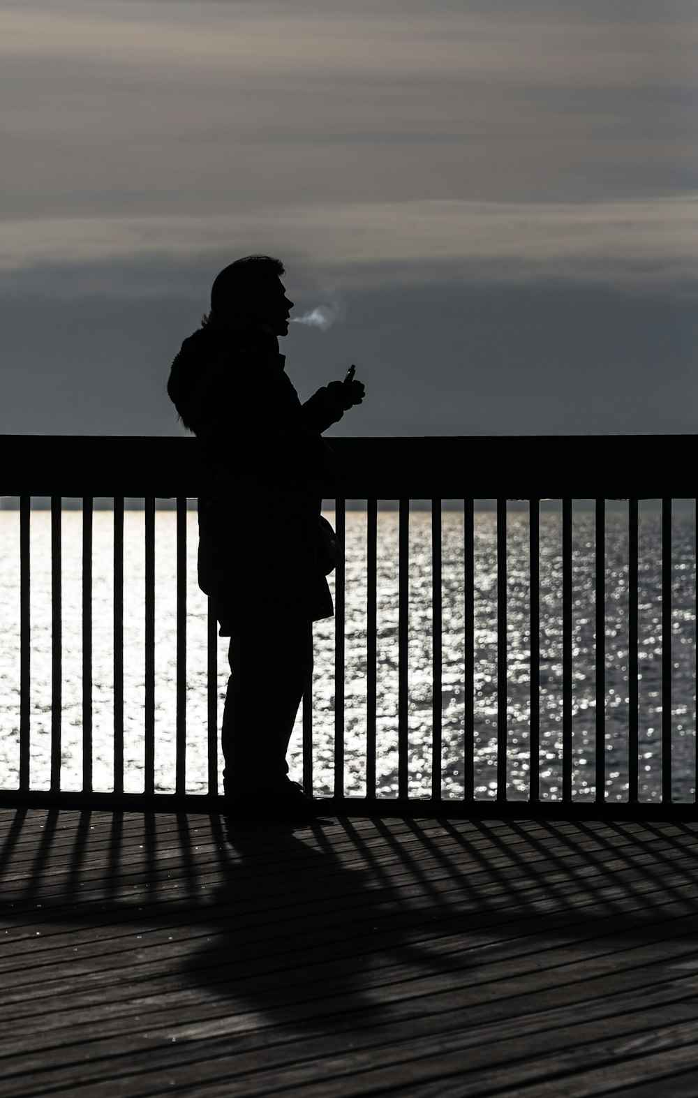 person using vape near body of water