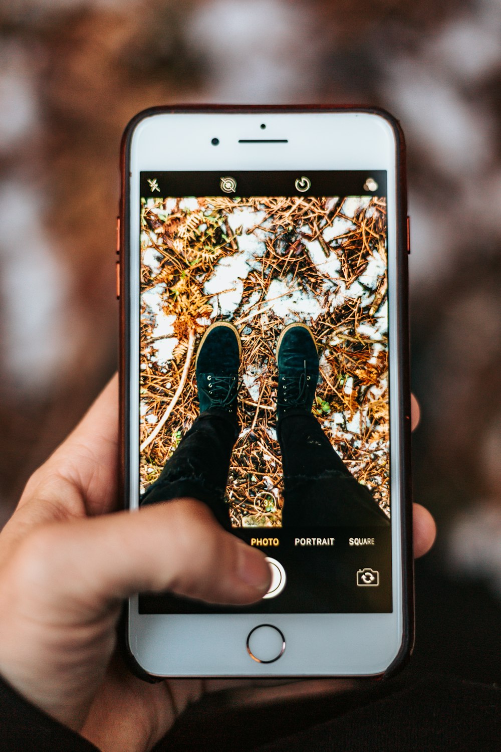 person holding iPhone taking photo of shoes