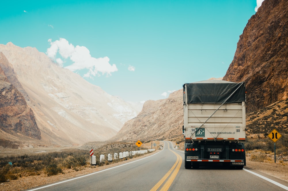 Camion blanc et noir près de la montagne pendant la journée