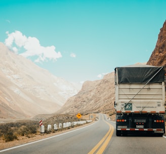 white and black truck near mountain at daytime