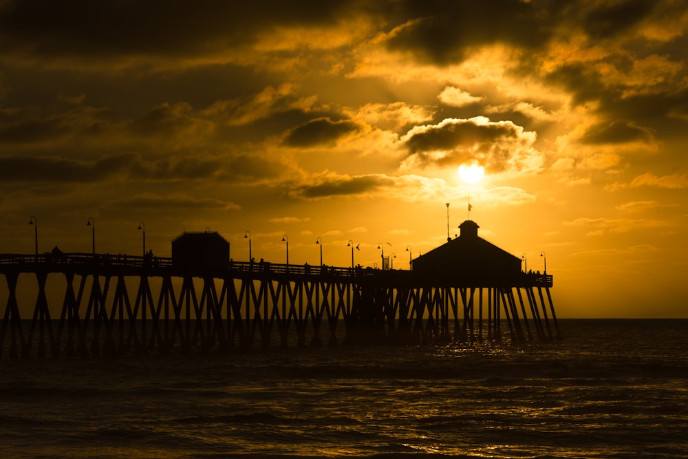 photo de silhouette de quai de mer à l’heure dorée