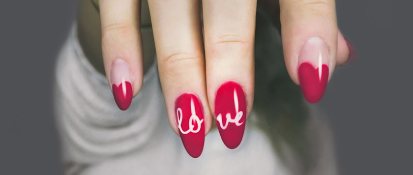 selective focus photography of woman's pink manicure