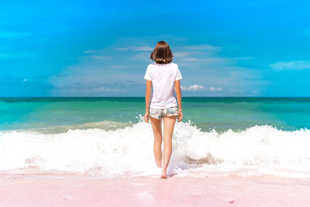 time lapse photography of woman standing in front of sea waves