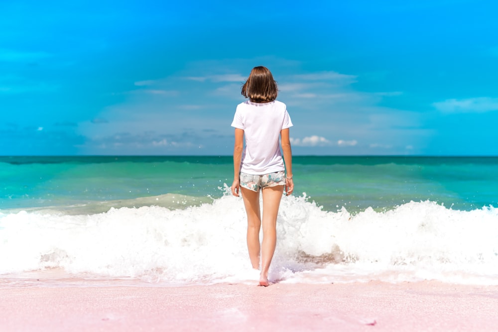 time lapse photography of woman standing in front of sea waves