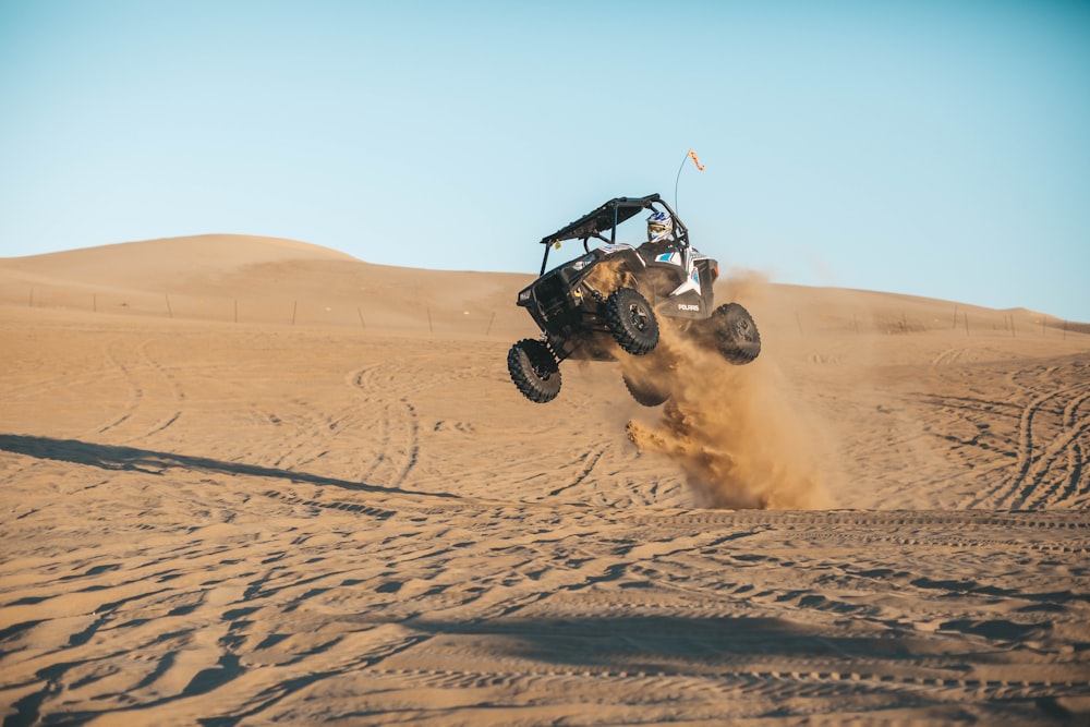 homme chevauchant un UTV dans le désert pendant la journée