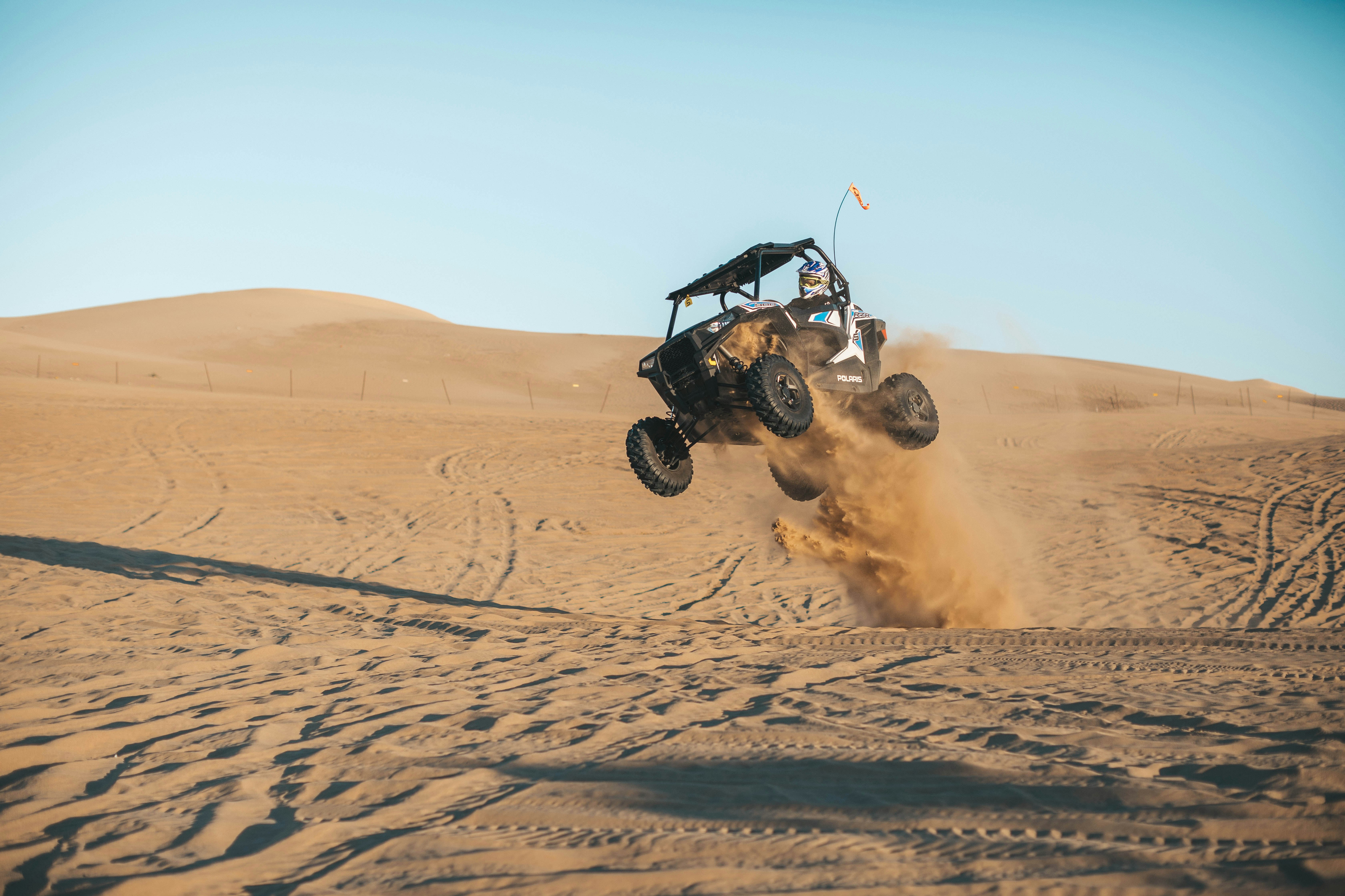 man riding on UTV on desert during daytime