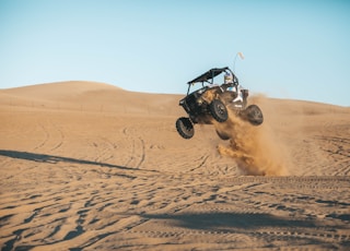 man riding on UTV on desert during daytime