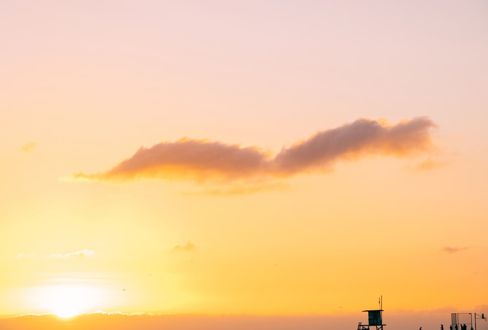 silhouette of shed under orange sky during sunset