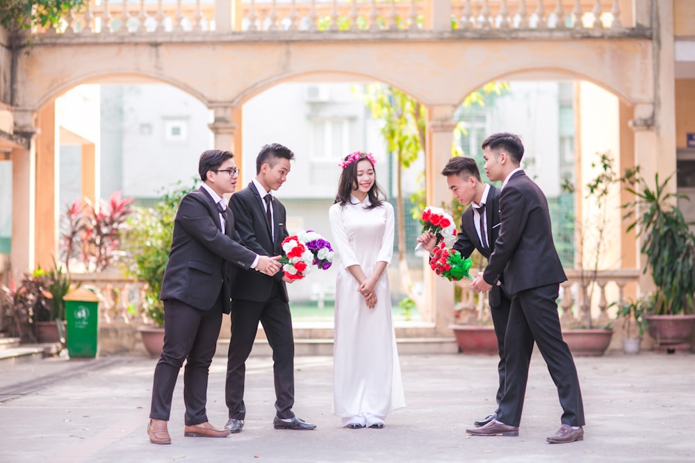 woman standing between four men