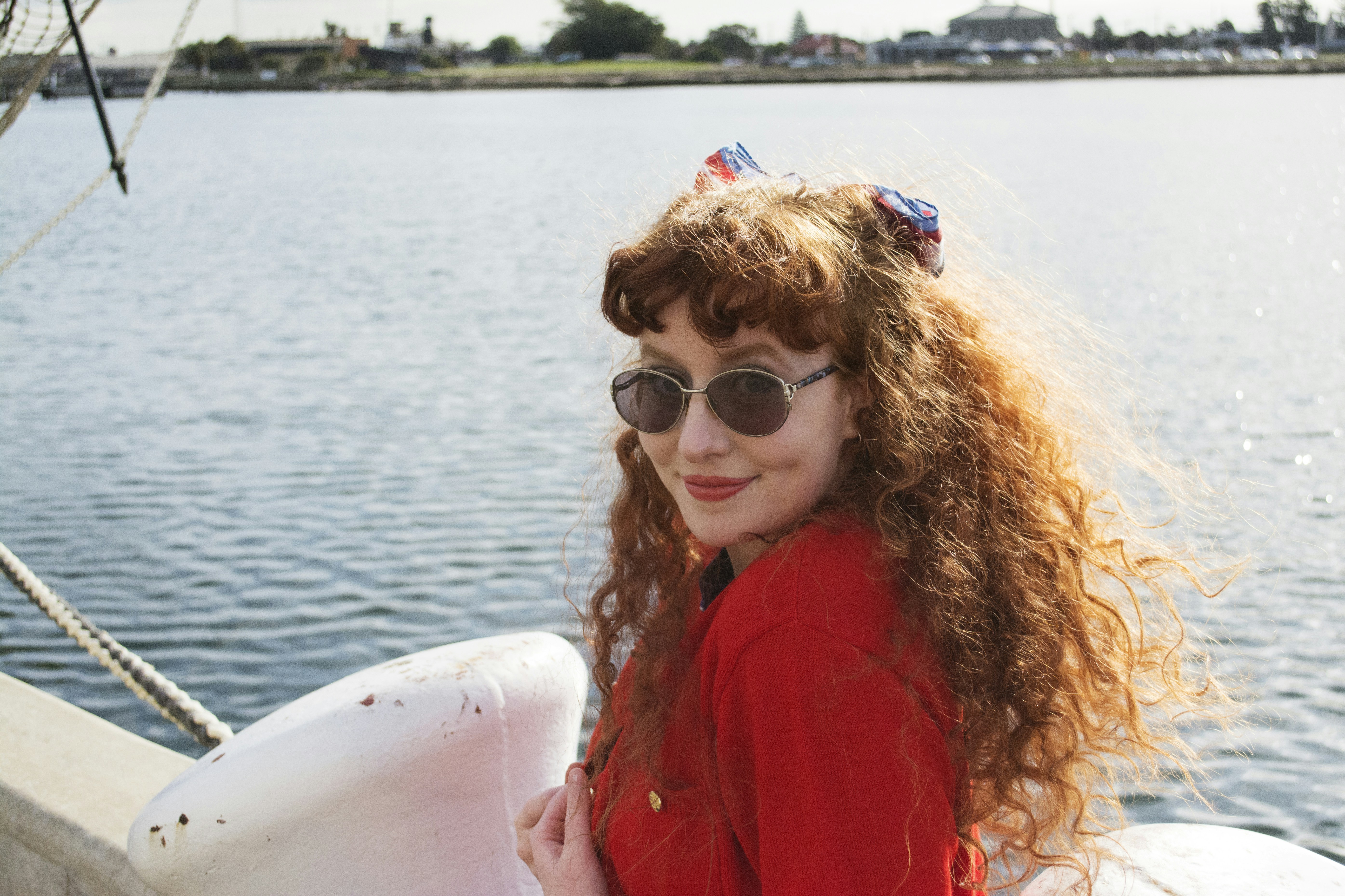 a woman on a boat wearing red curly hair extensions