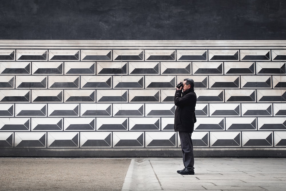 man holding camera near wall