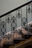 Custom staircase featuring wrought iron balusters and rich wood steps.