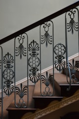 Close-up of a custom-built staircase with wrought iron railing and wooden steps