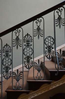 Custom staircase featuring wrought iron balusters and rich wood steps.