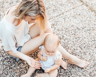 woman and a baby sitting on the ground