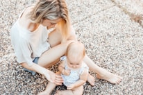 woman and a baby sitting on the ground