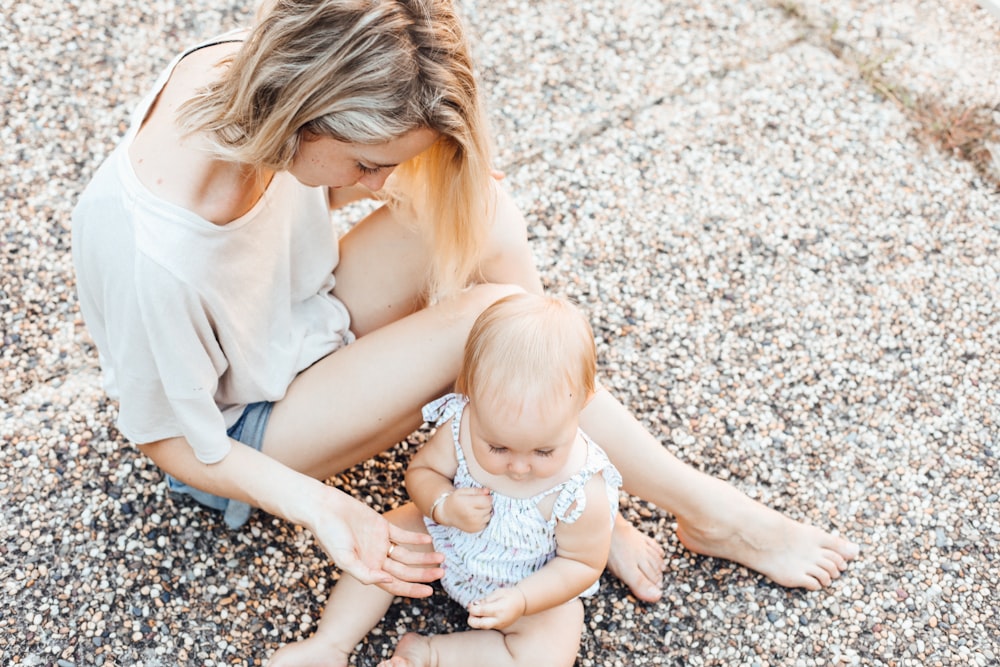 woman and a baby sitting on the ground