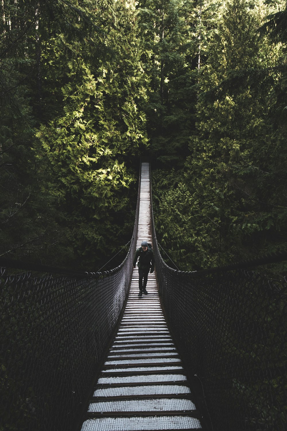 foto dell'uomo che cammina del ponte pedonale