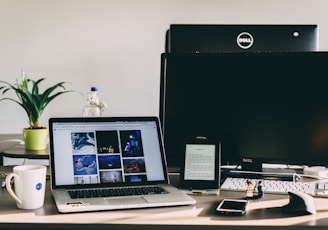 black and gray laptop computer near flat screen monitor