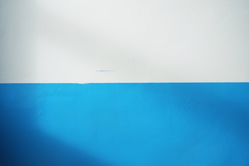 A clean, white partition wall separating two rooms.