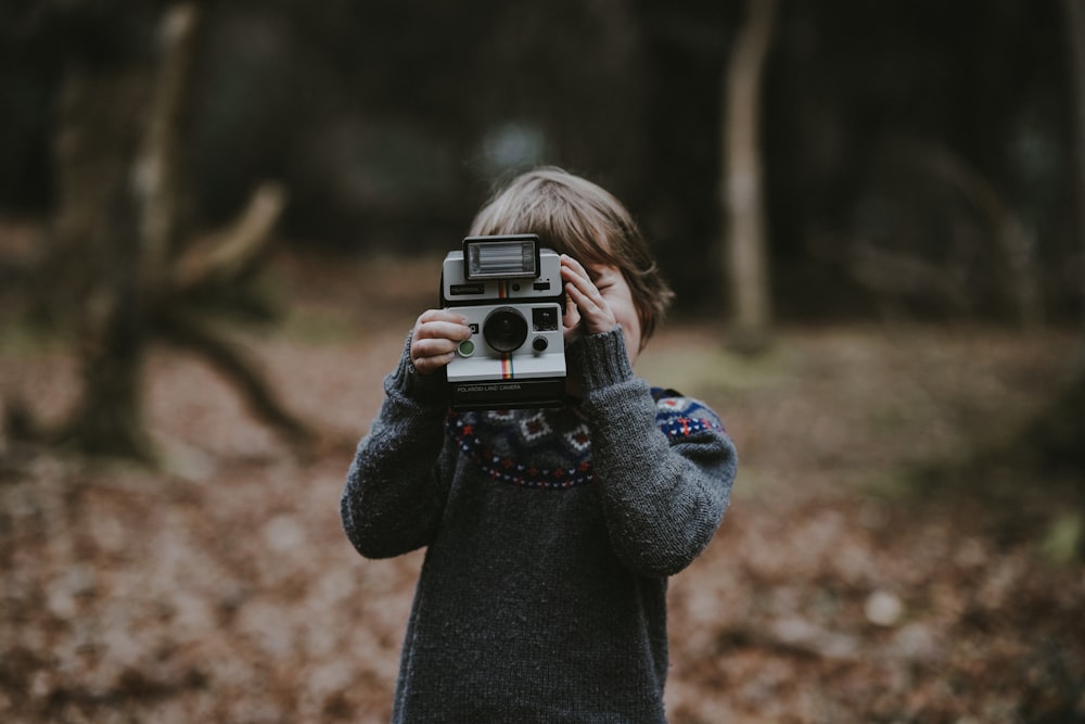 kid holding camera