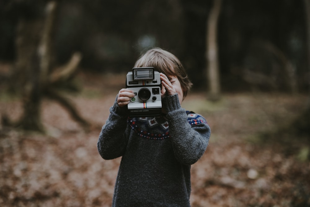 bambino che tiene la macchina fotografica