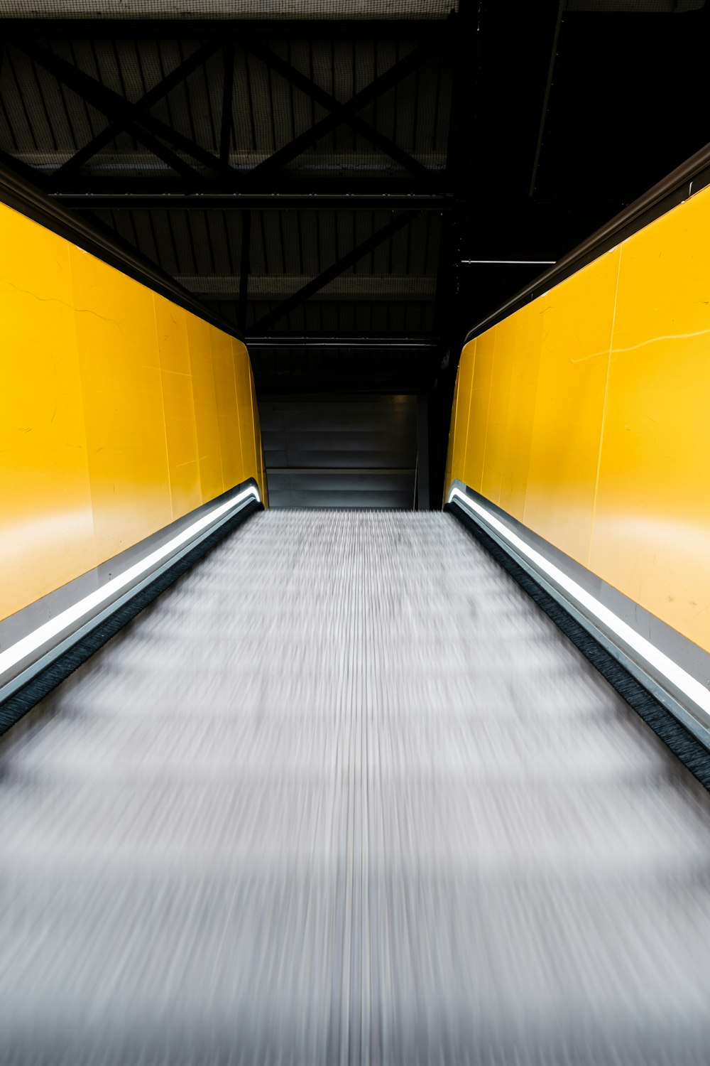 moving escalator with yellow handrails