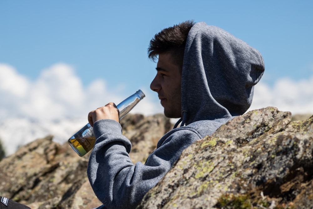 man drinking on bottle under sunny sky