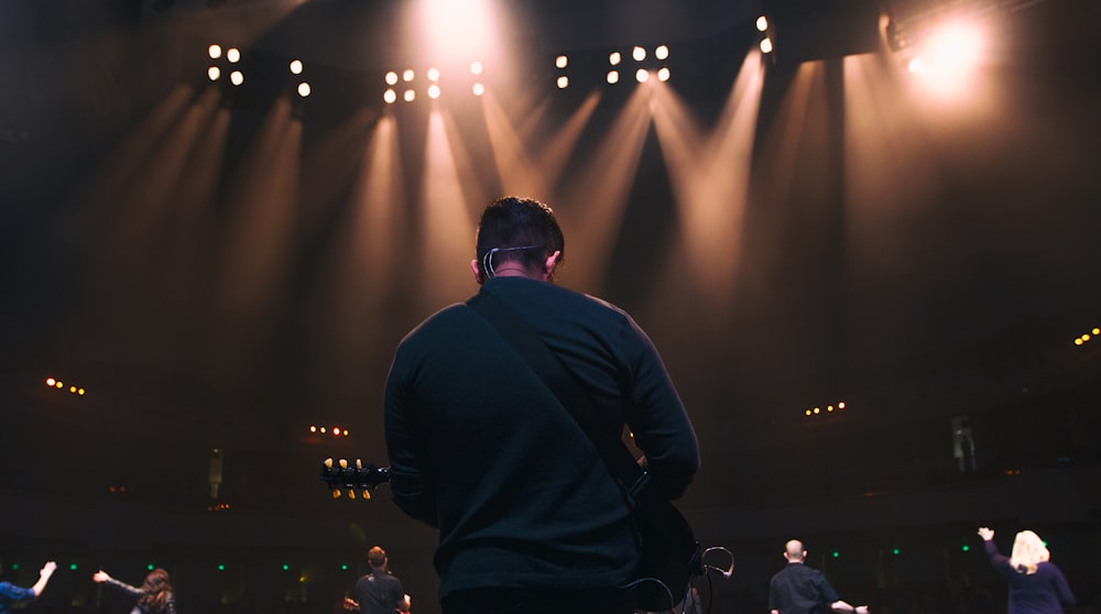 man playing guitar in concert