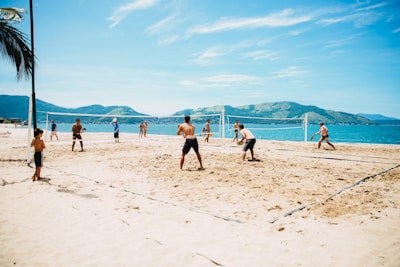 Smiling kids and adults enjoying a sunny beach volleyball tournament