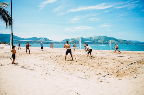 Group of friends playing beach volleyball on a sunny day.