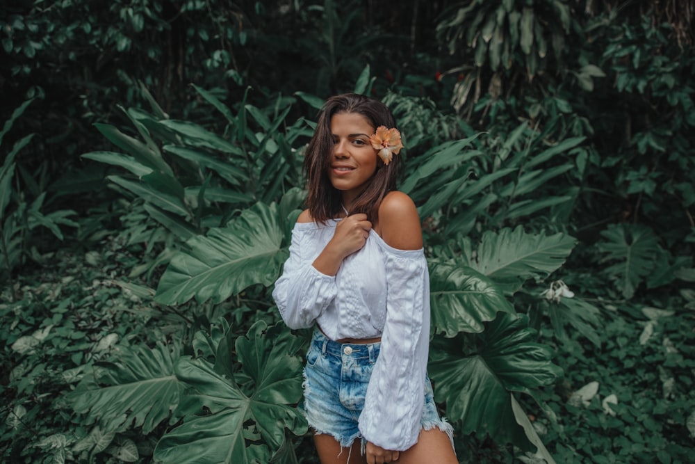 woman in off-shoulder shirt in front of green leafed plants
