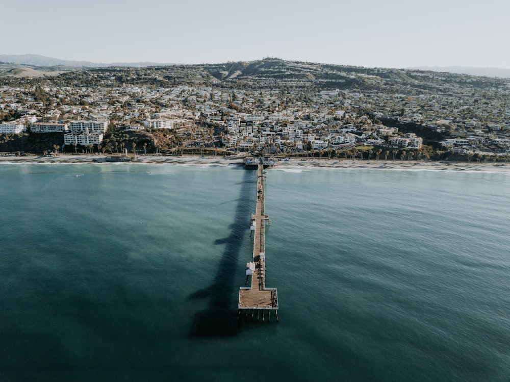 Dock in der Nähe von Häusern, die tagsüber vom Meer umgeben sind