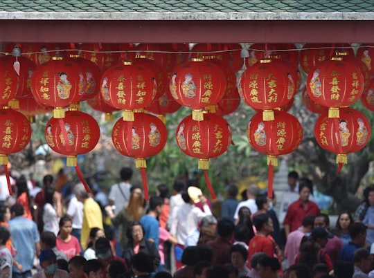 hanging round red lanterns near crowd at daytime in Saraburi Thailand