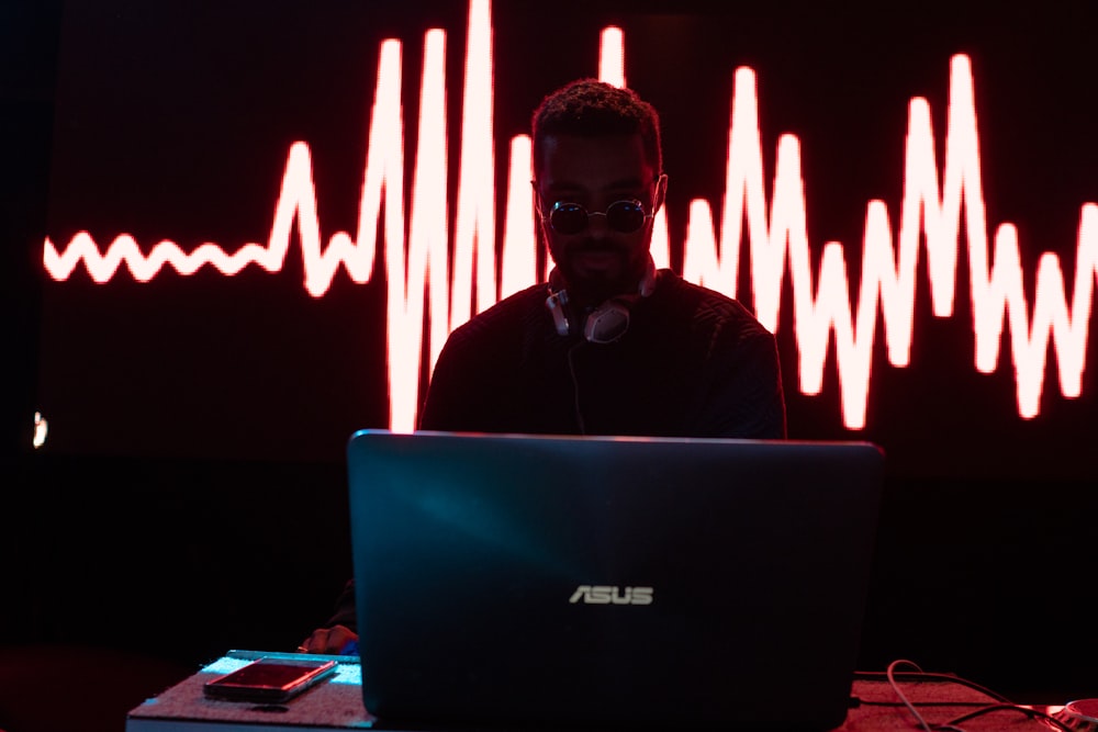 man standing in front Asus laptop