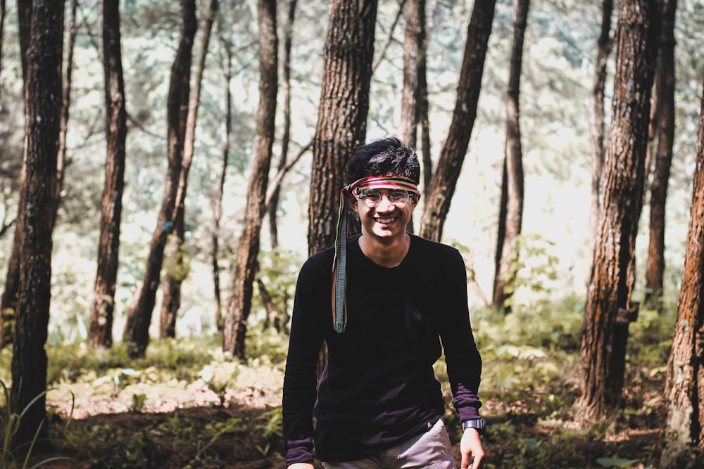 man wearing black shirt walking inside forest