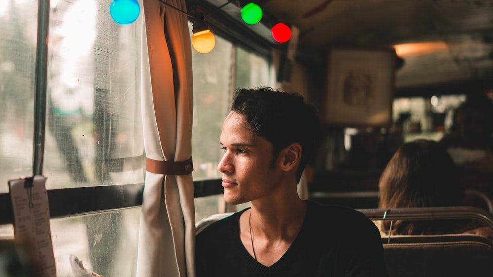 man sitting on chair looking near window