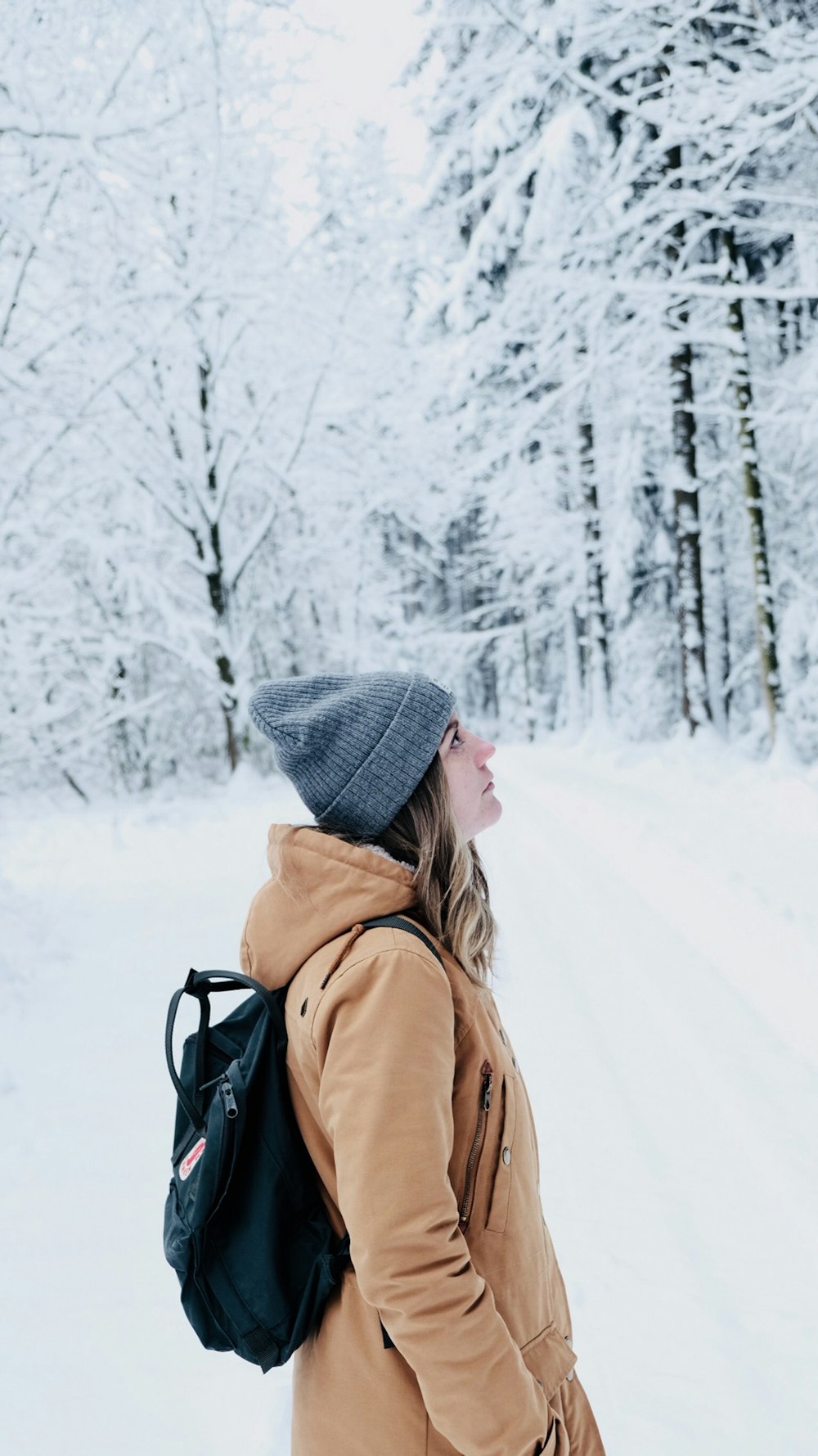 Frau geht im schneebedeckten Wald spazieren