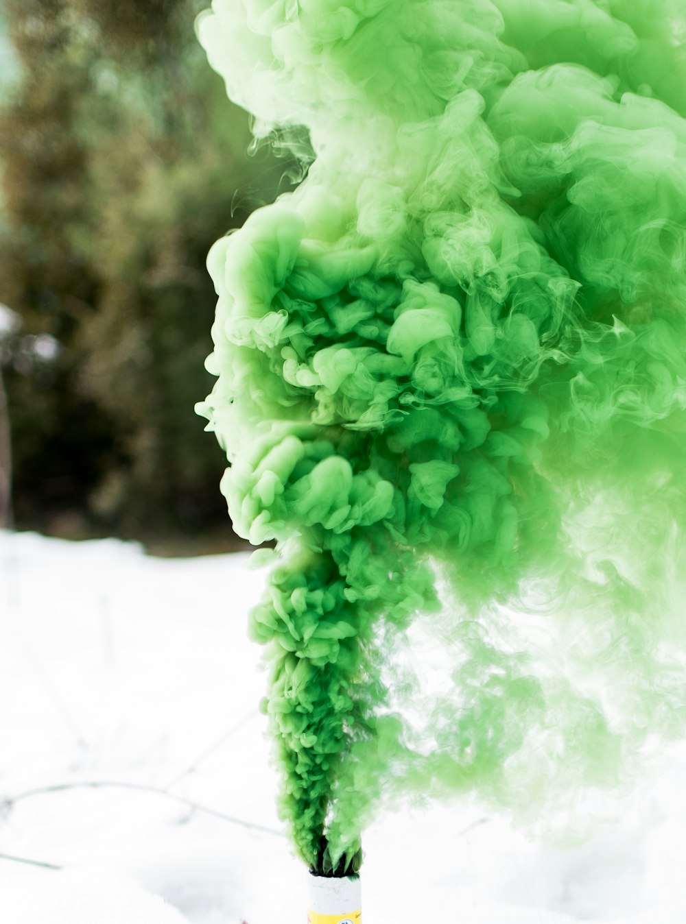 shallow focus photography of canister producing green smoke