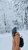 shallow focus photography of woman standing on snow field looking her backj