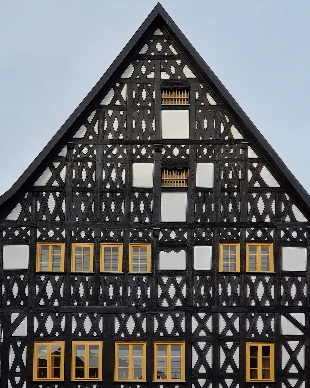 black, beige, and white wooden building with multiple windows