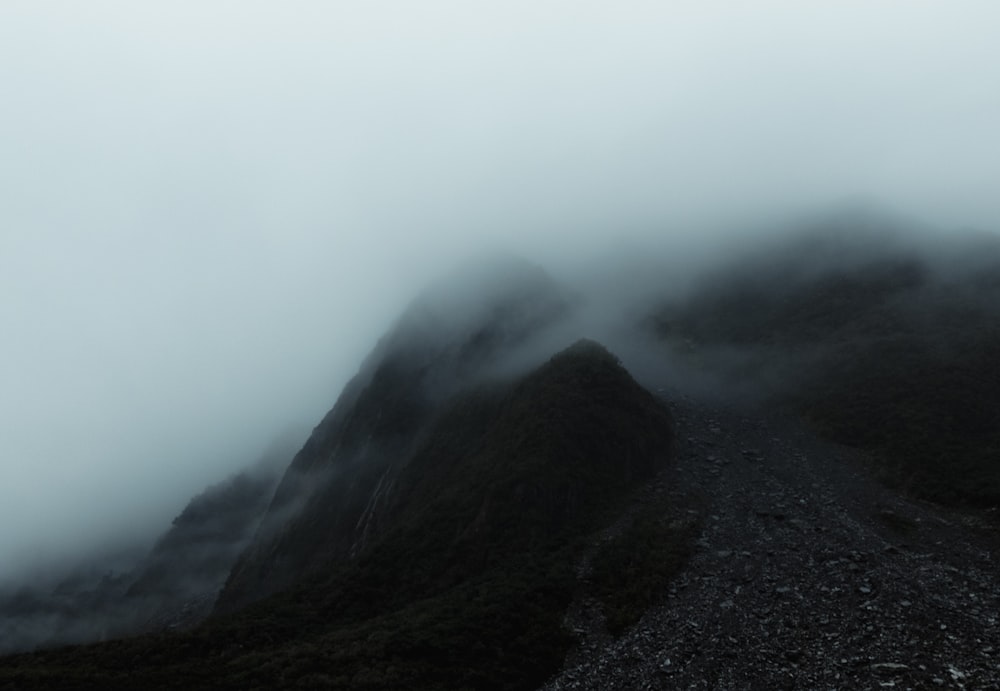 茶色の山の頂上を覆う白い雲の風景写真