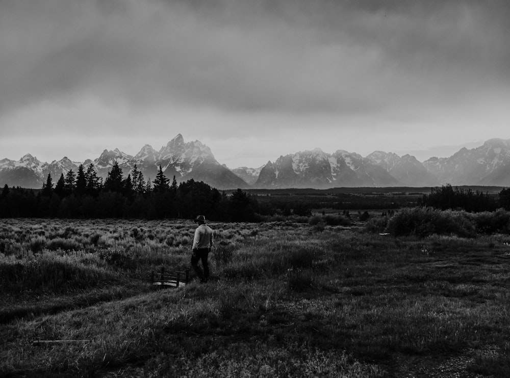 fotografia em tons de cinza da pessoa em pé no campo