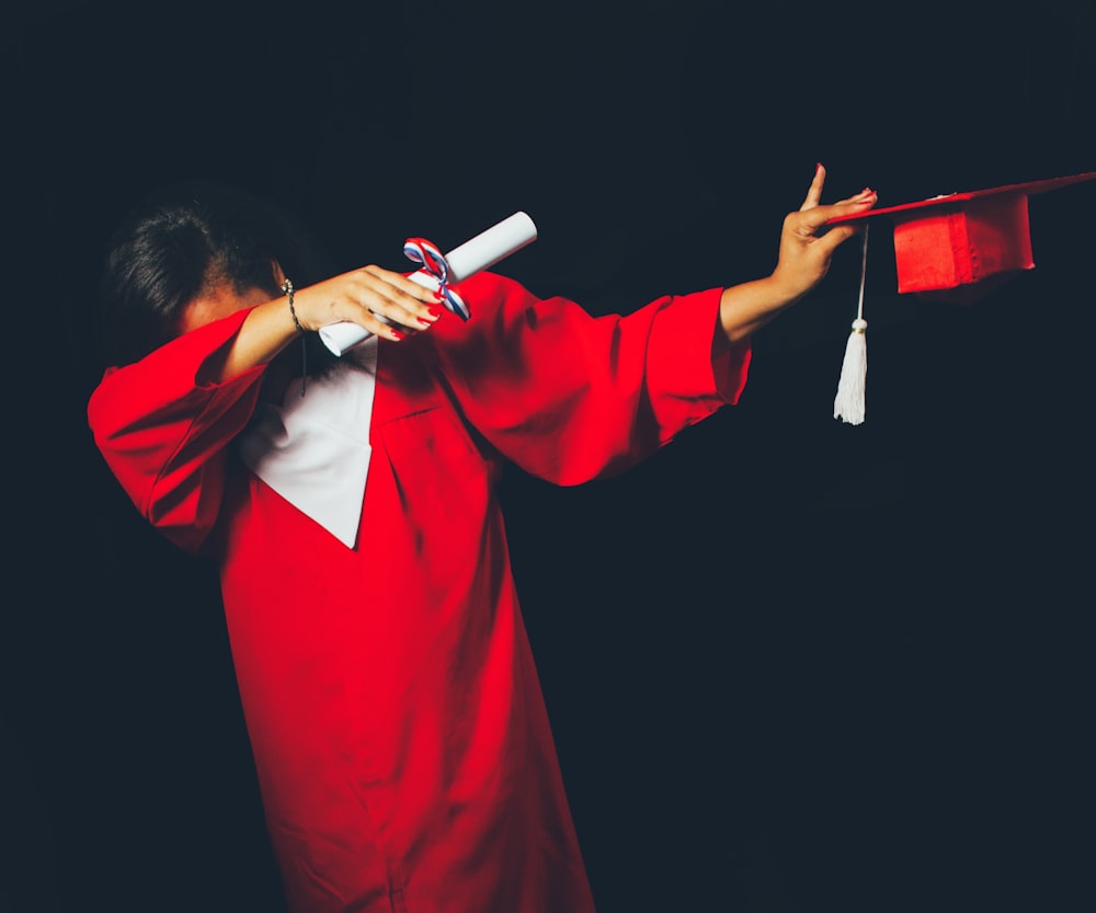 persona che indossa il vestito rosso di laurea