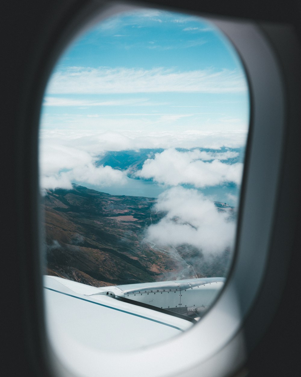 Foto aérea de montañas y nubes bajo el cielo azul