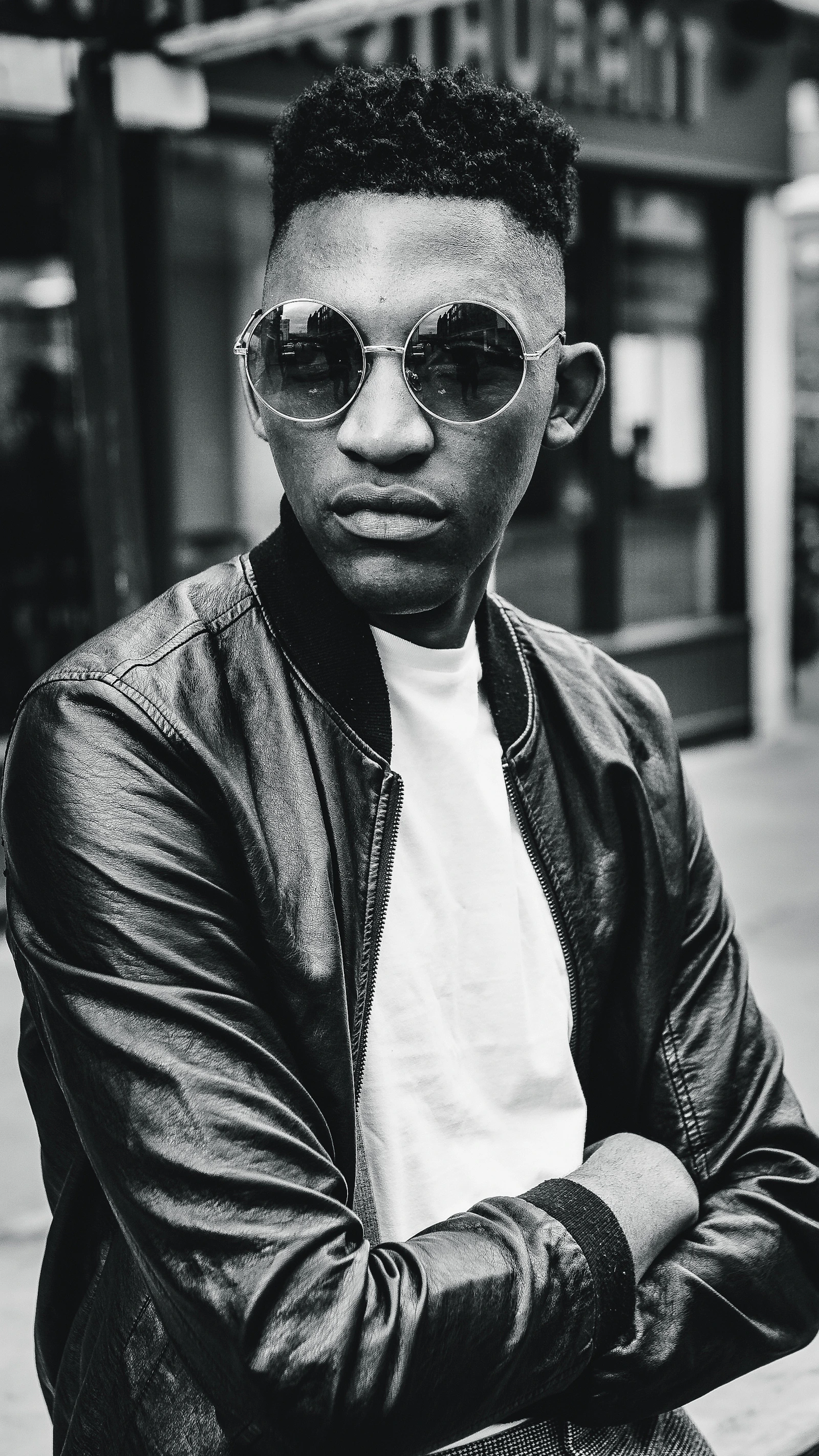 Grayscale editorial portrait of a model wearing a bomber jacket