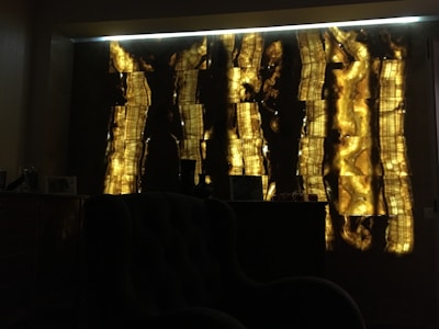 Wide shot of a luxurious dark room with subtle warm gold highlights and glass-morphism panels.